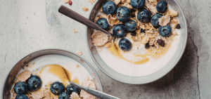 two bowls of yoghurt, granola and blueberries